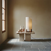 small Wabi-sabi floor lamp with wooden base and cylindrical fabric shade, placed in a minimalist interior with natural tones